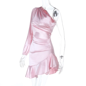 Détails de la texture satin rose avec fronces et ourlet asymétrique à volants