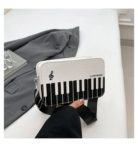 Detail of creative piano keyboard crossbody bag with I Love Music print and canvas texture