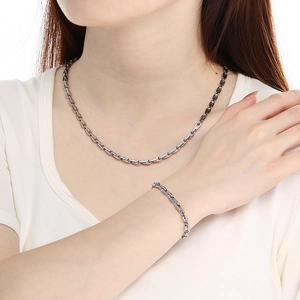 Ensemble collier et bracelet en maille grain de café en acier inoxydable sur modèle