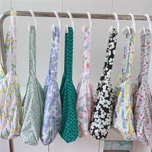 Selection of printed cotton tote bags with floral and geometric patterns on a rack