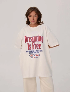 Dettaglio della stampa slogan Dreaming Is Free su t-shirt oversize bianca