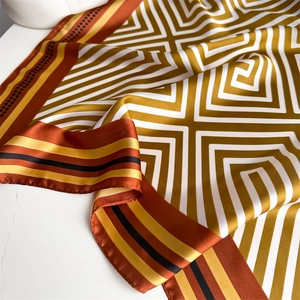 Vue détaillée d'un foulard carré en satin avec motifs géométriques et fini soyeux
