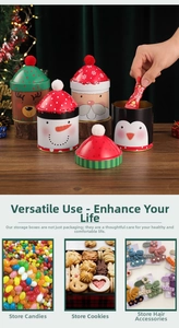 Christmas tin canisters with elk and Santa designs and festive plush pom-pom lids