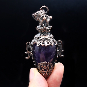 Macro view of vintage bronze hollow pendant with purple crystal and intricate carvings