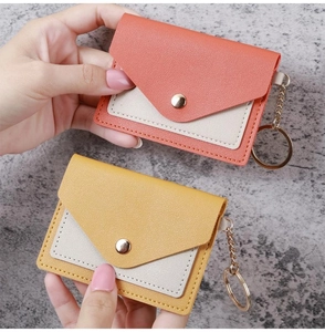 Close-up of coral orange and ginger yellow PU leather card holders with gold keychains