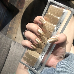 Detail of gold diamond grid nail polish wraps with display of application and packaging