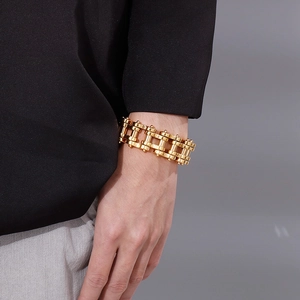 Close-up of a 22mm gold stainless steel bike chain bracelet on a male model wrist