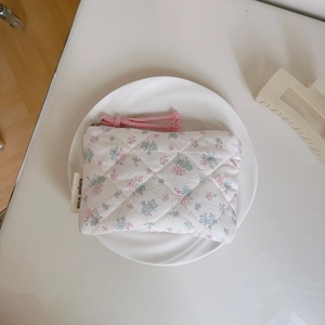 Macro detail of floral quilted mini pouch with small pink flowers and pink zipper cord