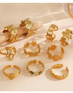 Macro detail of gold-plated stainless steel flower rings with intricate daisy floral designs