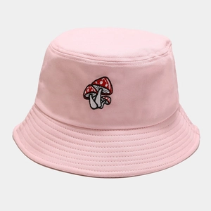 Gros plan de la broderie champignon sur le chapeau bob en coton rose avec surpiqûres