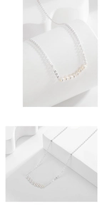 Detailed view of silver S925 necklace with a row of small white pearls in minimalist style