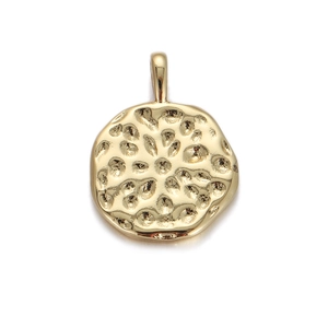Detailed view of round golden pendant with hammered metal texture and top loop