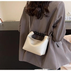 Silver mini bag with lychee texture featuring a black pearl handle and chain strap