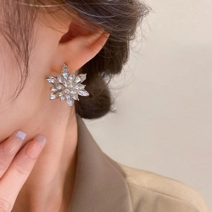 Close-up of elegant crystal flower stud earrings on model for a sophisticated look