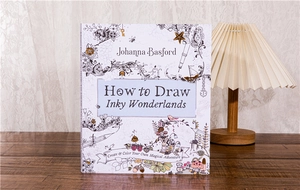 Johanna Basford How to Draw Inky Wonderlands book on a wooden desk with a lamp