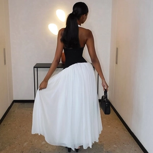 Elegant back view of backless black and white maxi dress with pleated skirt and halter neck