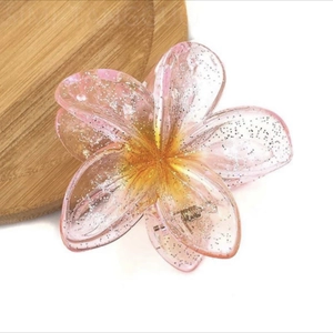 Macro shot of pink gradient flower hair claw clip with glitter details and spring