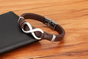 Detail of brown braided leather bracelet with stainless steel infinity symbol and clasp