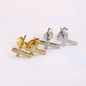 Detail showing gold and silver 6mm cross stud earrings with sparkling cubic zirconia stones