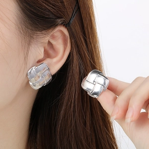 Macro shot of silver square woven texture earrings showing the polished steel finish