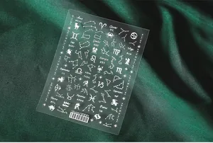 Detailed view of 5D white constellation nail stickers on premium dark green silk fabric