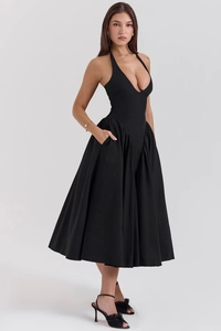 Detail of elegant black halter neck dress with deep V-neck and ruffled waist pleats