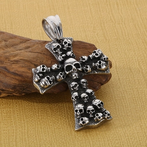 Detailed view of a gothic skull cross pendant with vintage silver finish on wood