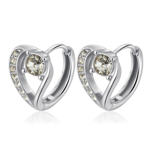 Macro detail of silver heart earrings with sparkling cubic zirconia on a white backdrop