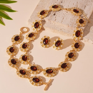 Vintage gold jewelry set with oval amber stones and floral details on a stone base