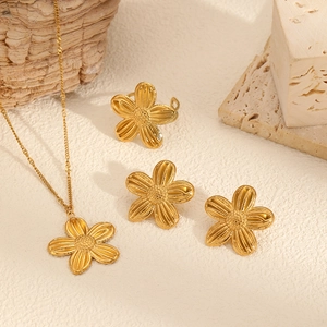 18k gold plated sunflower jewelry set with necklace, ring and earrings on stone