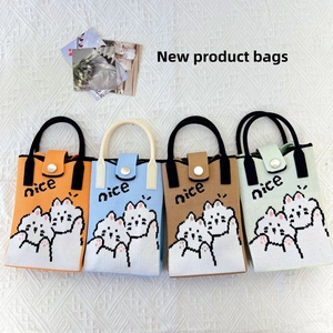 Flat lay of four colorful knitted mini bags featuring cute cat patterns and nice text