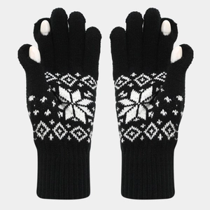 Detail of black knitted fingerless gloves with white snowflake and geometric patterns