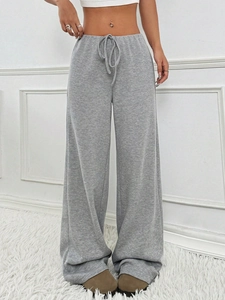 Detail of grey knitted wide-leg drawstring pants with vertical texture on model