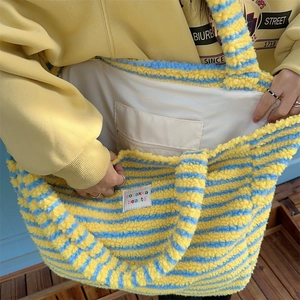 Detail shot of the plush tote bag interior with zipper pocket and fuzzy striped texture