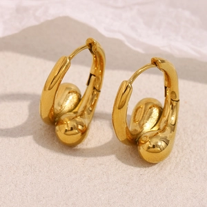 Vue macro de boucles d'oreilles en acier inoxydable doré 18K en forme de goutte d'eau irrégulière