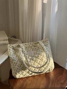 Vue détaillée d'un sac cabas en velours côtelé matelassé avec des motifs de cœur