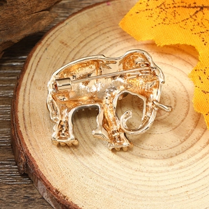 Detailed back view of a golden elephant brooch showing the safety pin and metal texture
