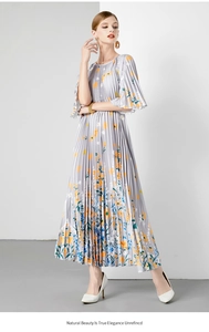 Detail van grijze geplooide maxi-jurk met bloemenprint en wijd uitlopende mouwen