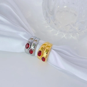 Elegant 18k gold and silver titanium rings set with oval red zircon stones on silk