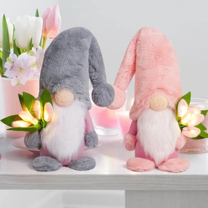 Close-up of glowing LED tulip bouquet held by plush spring gnome for festive decoration