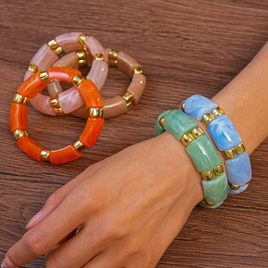 Detail of colorful acrylic bamboo segment bracelets with golden alloy spacers for women