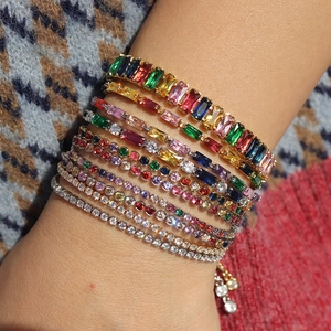 Macro shot of layered tennis bracelets with colorful baguette and round cut cubic zirconia