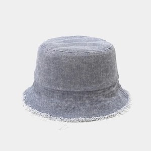 Gros plan détaillé des bords effilochés et du tissu denim d'un chapeau bob bleu