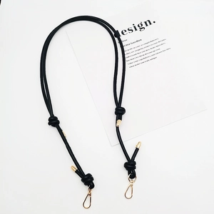 Close-up of black PU leather adjustable shoulder strap with knot and gold metal buckle