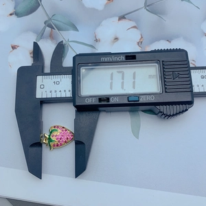 Macro shot of strawberry pendant measured by digital caliper showing 17.1 mm size