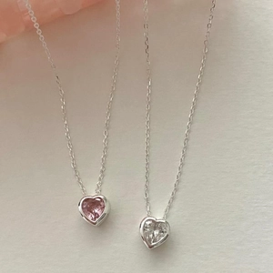 Macro shot of silver heart necklaces with sparkling pink and clear cubic zirconia stones
