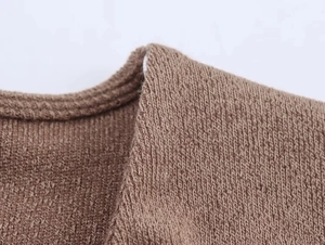 Primer plano del top de punto marrón mostrando detalles del cuello y hombro