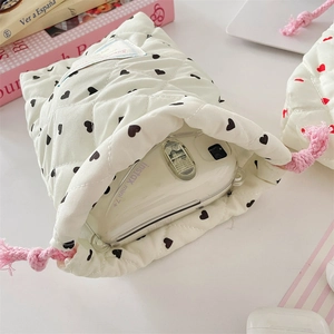 Quilted cream drawstring pouch with black heart pattern for compact camera protection