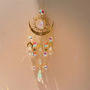 Golden sun and moon suncatcher with crystals casting rainbow reflections on wall