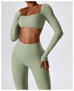 Détail d'un ensemble de yoga vert sauge avec haut à manches longues et legging taille haute